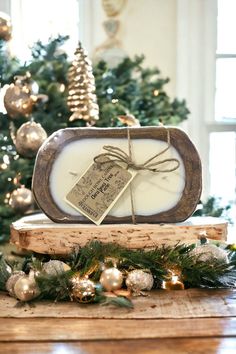 a wooden box with a tag tied to it sitting on top of a table in front of a christmas tree