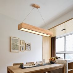 a dining room table with some fruit on it and pictures hanging above the table in front of them