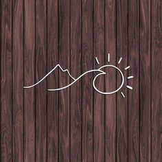 a wooden background with the sun and mountains drawn in white ink on wood planks