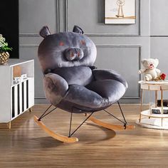 a grey teddy bear rocking chair sitting on top of a hard wood floor