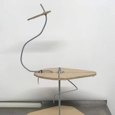 a wooden table with a metal object on it's top and an ironing board attached to the base