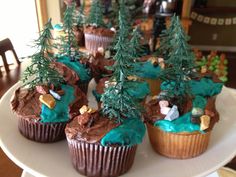 cupcakes decorated with trees and rocks on a plate