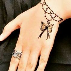 a woman's hand with a tattoo on it and a chain around her wrist