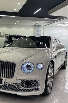 a white car is parked in a showroom