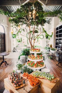 a table filled with lots of food on top of wooden trays next to a tree