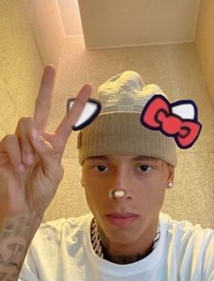 a person with a beanie on their head making the peace sign