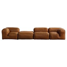 a brown leather couch with four seats and one arm folded out to the side, on a white background