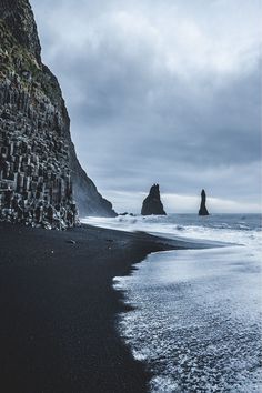 Reynisfjara, a beach of black sand and pebbles smoothed by the sea unique in the world, two majestic stacks emerge from the fog and then flow into the sea Iceland Honeymoon, Iceland Winter, Vacation Locations, Travel Finds, Peru Travel, The Fog