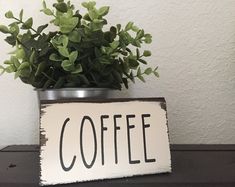 a potted plant sitting on top of a table next to a sign that says coffee