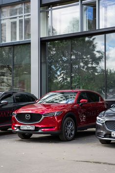 three mazda cars parked in front of a building