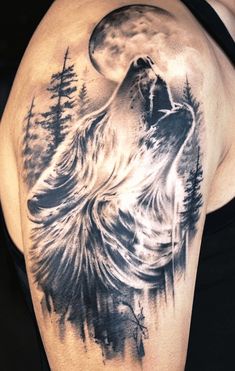 a man's arm with a wolf tattoo on it and trees in the background