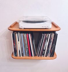 a record player is sitting on top of a shelf filled with cds and cassettes