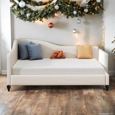 a white couch sitting under a christmas tree