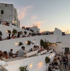 many people are sitting at tables outside on the roof terrace and enjoying their evening meal