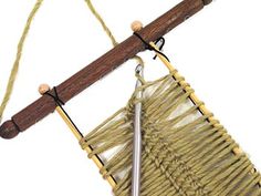 a close up of a macrame hanging from a wooden pole with two handles