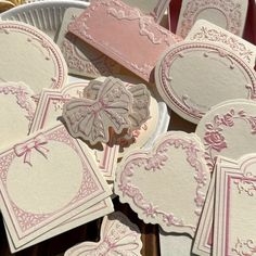 some pink and white heart shaped cards on a table with paper doidles in the shape of hearts