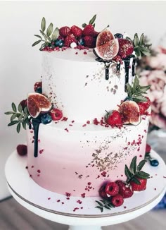 a three tiered cake with fruit and berries on top