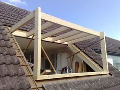 an open window in the roof of a house that's being built on top of a building