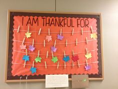 a bulletin board with clothes pins and paper leaves on it that says i am thanksgiving for