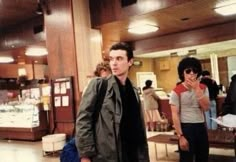 a man is standing in an airport waiting for his luggage