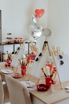 the table is set up with easels and cupcakes for valentine's day