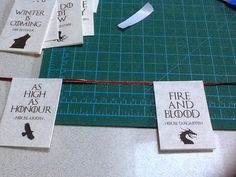 four bookmarks are laid out on a table with scissors and tape to make them look like they have fire and blood written on them