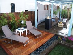 an outdoor living area with patio furniture and wooden decking, surrounded by greenery