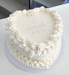 a white wedding cake with the words just married on it's frosting heart