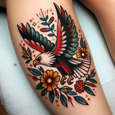 an eagle with flowers and leaves on the thigh is shown in this tattoo design by person