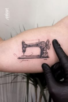 a sewing machine tattoo on the arm