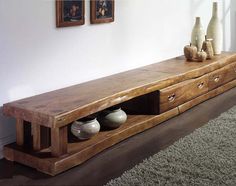 a wooden table with two vases on it and a rug in front of it