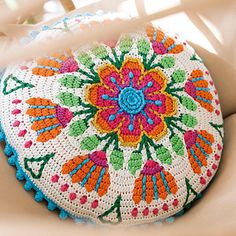 a white crocheted purse with multicolored flowers