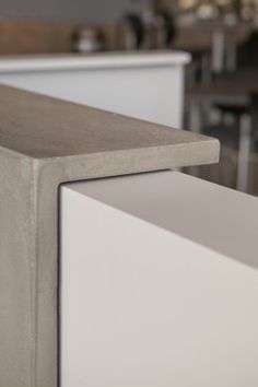 a close up view of a counter top in a restaurant or bar area with chairs and tables behind it