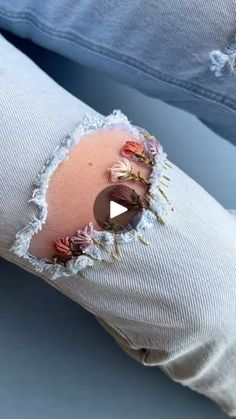 a person's jeans with holes and flowers pinned to the back of their pants