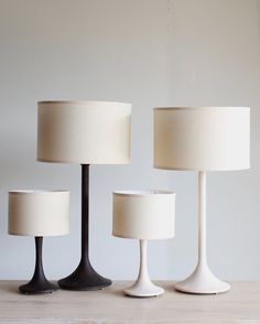 three lamps sitting on top of a wooden table