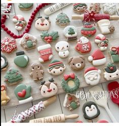 christmas cookies are arranged on a table with holiday decorations and cookie cutters next to them