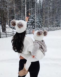 a woman holding a child in the snow