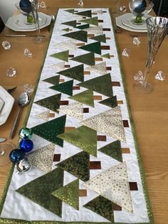 a table runner made out of green and white christmas trees on top of a wooden table