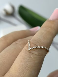 a close up of a person's hand with a diamond ring on their finger