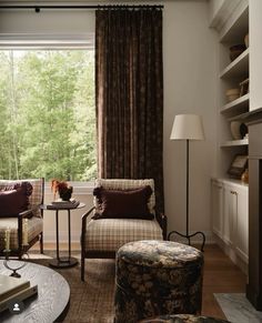 a living room filled with furniture and a fire place in front of a large window