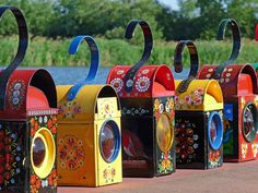 colorful mailboxes are lined up along the water's edge with decorative designs on them