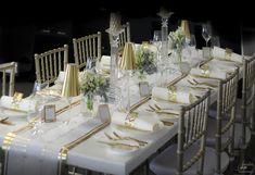 the table is set with gold and white decorations