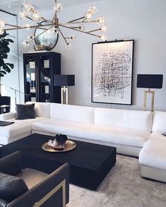 a living room with white couches and black tables