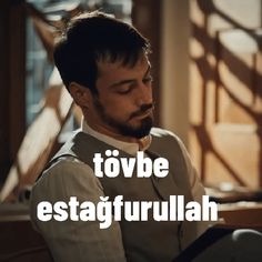 a man sitting on top of a wooden bench in front of a window with the words toube estagfrulah above it