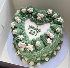 a heart shaped cake sitting on top of a blue plate next to a white box