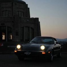 an old car is parked in front of a large building with a dome on top