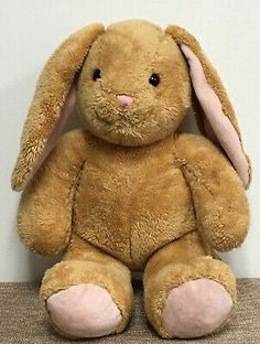 a brown stuffed rabbit sitting on top of a table next to a white wall and floor