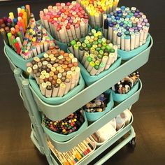 a cart filled with lots of different colored crayons and pencils on top of each other