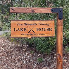 a wooden sign that says the demperer family lake house in front of some bushes