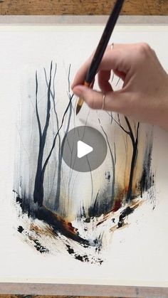 a person is holding a pencil and drawing trees